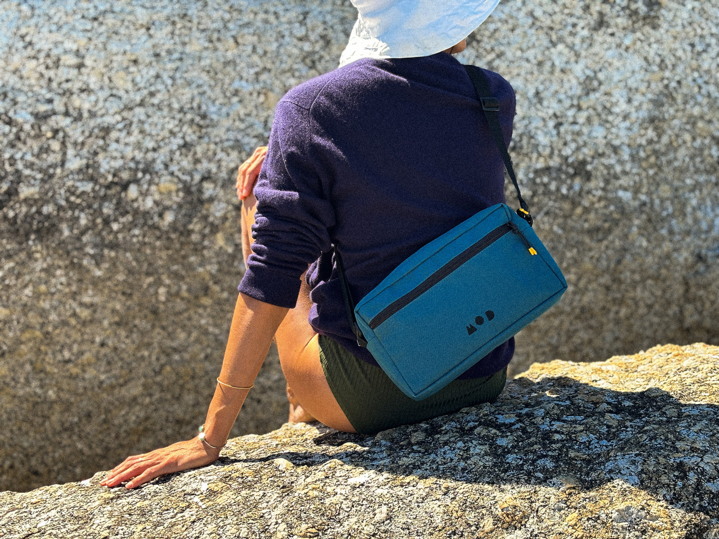 Anywhere Pouch in Teal slung across a woman