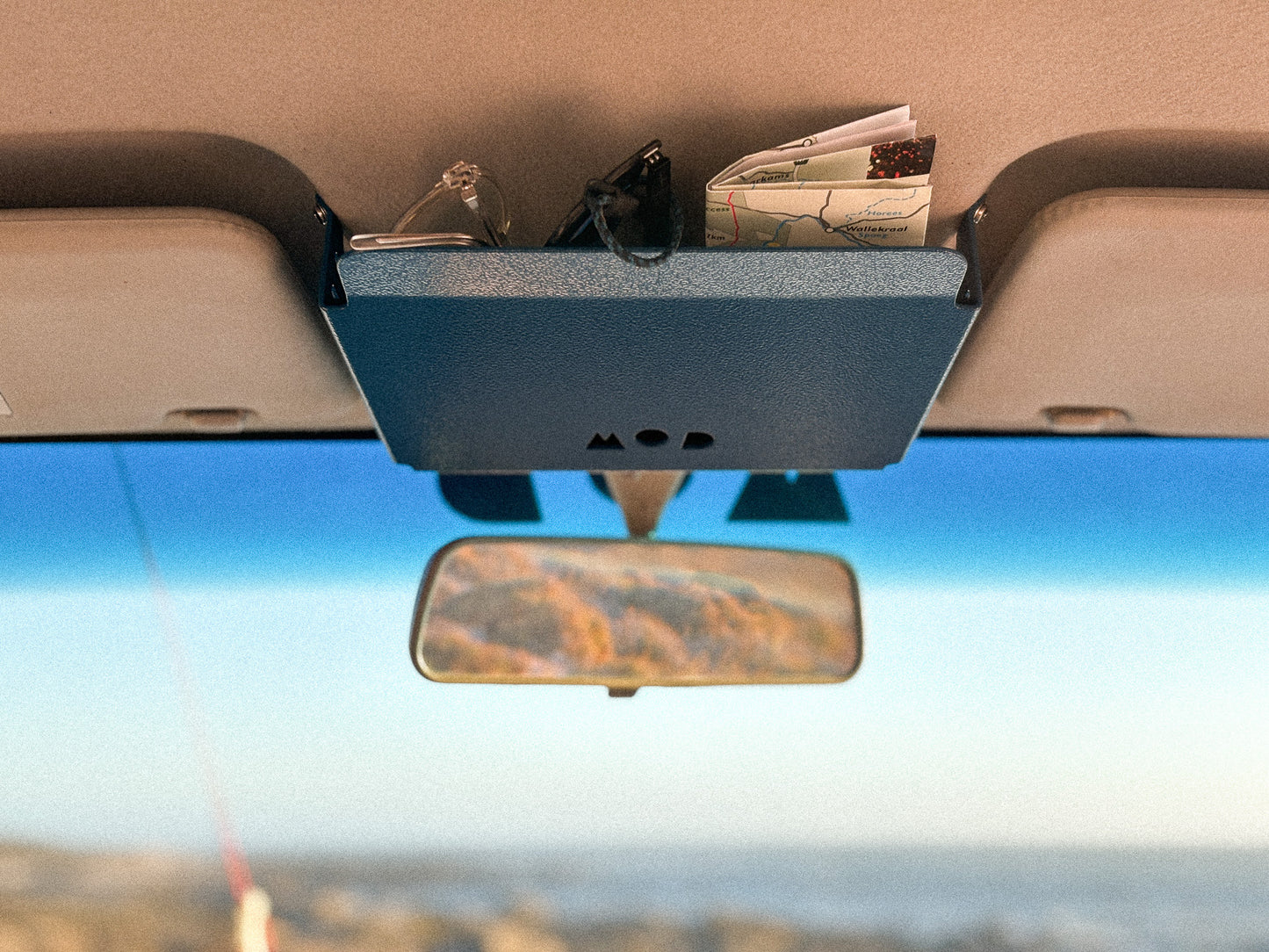 Headroom in Jimny 3 in Blue showing storage of glasses and maps between sun visors