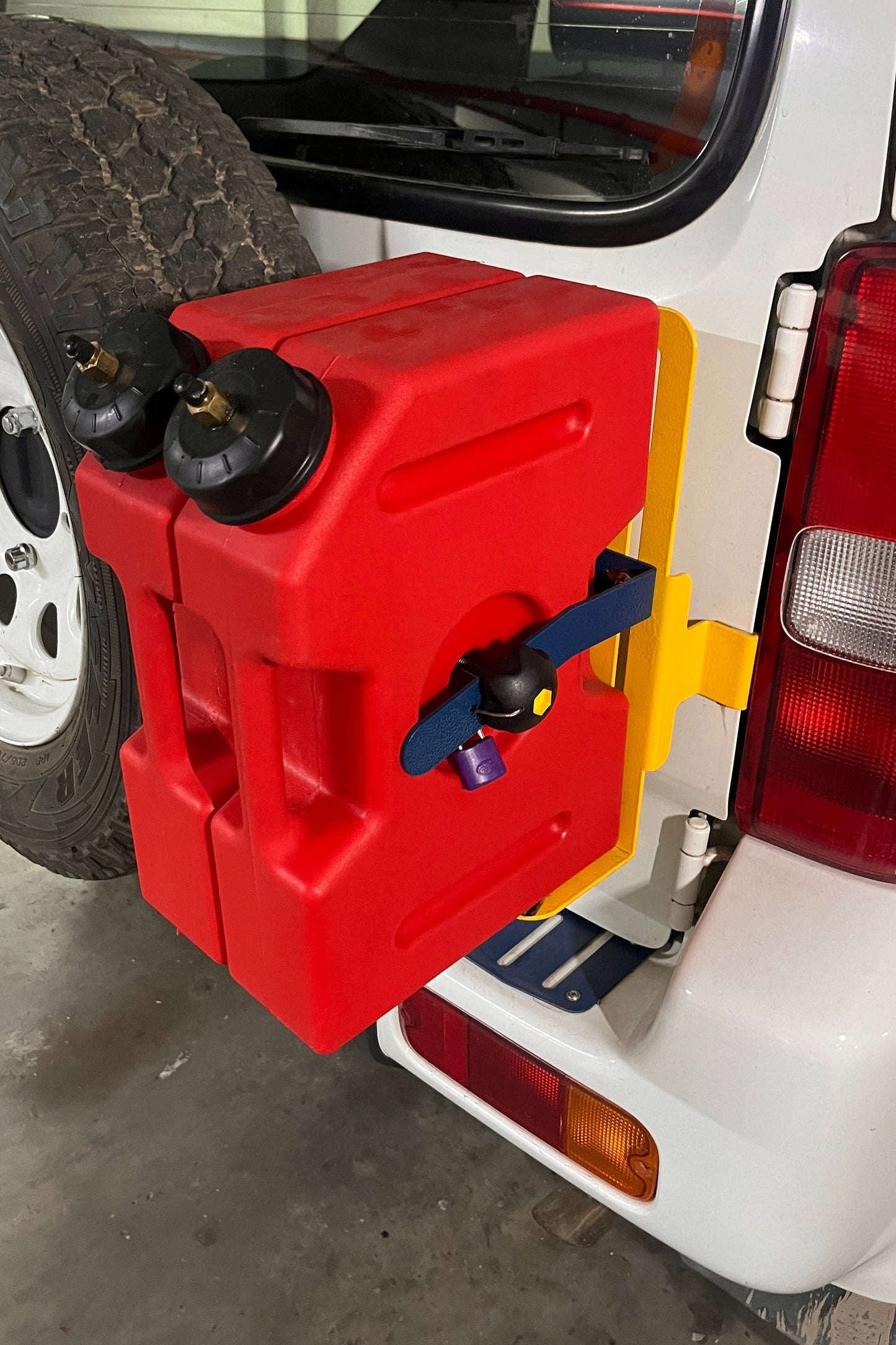 Red portable fuel tank attached to a Jimny 3 with MOD Rear Door Mount