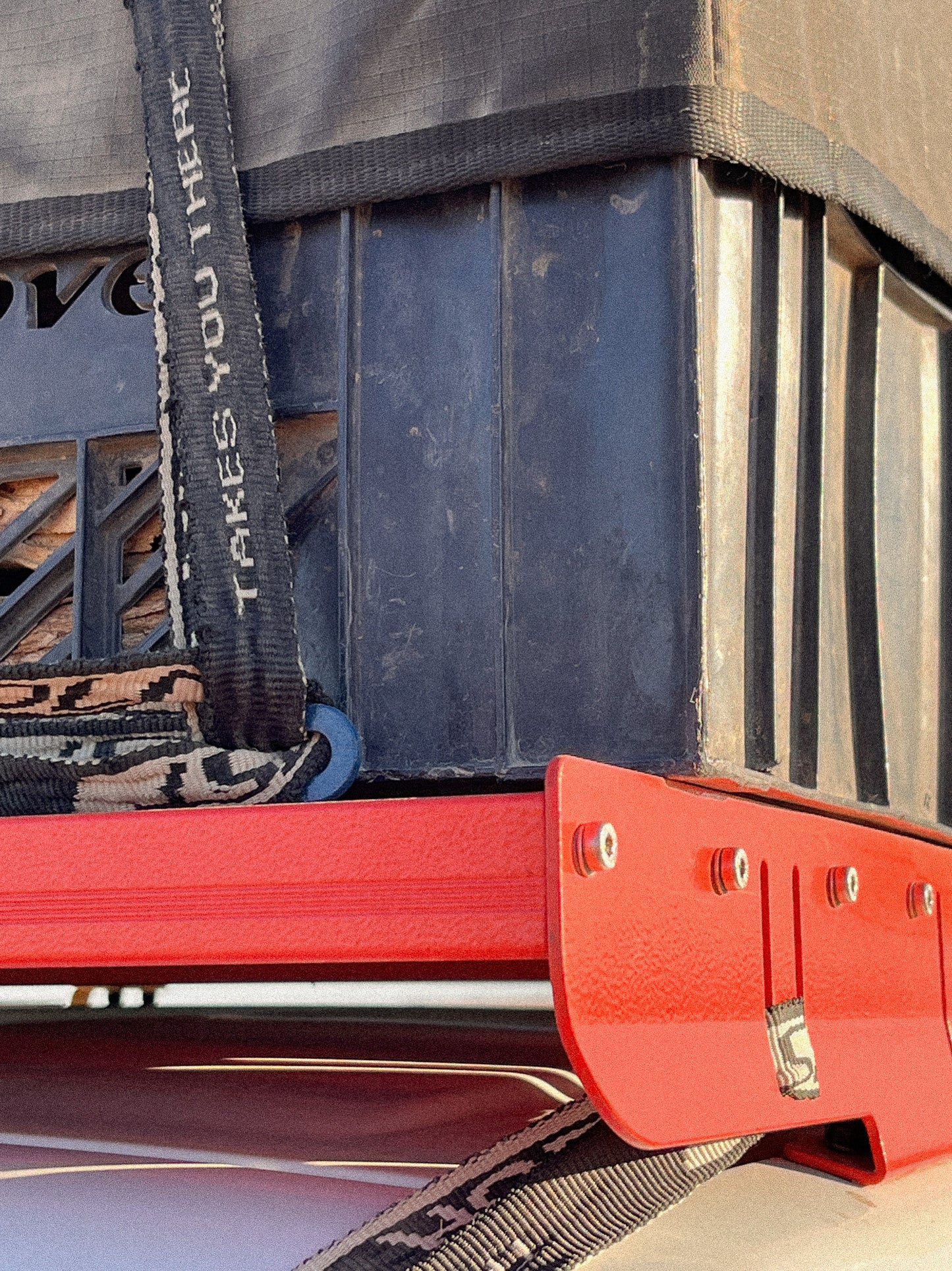 Lashing Point in Blue mounted on a Jimny 3 Roof Rack being used as a tie down