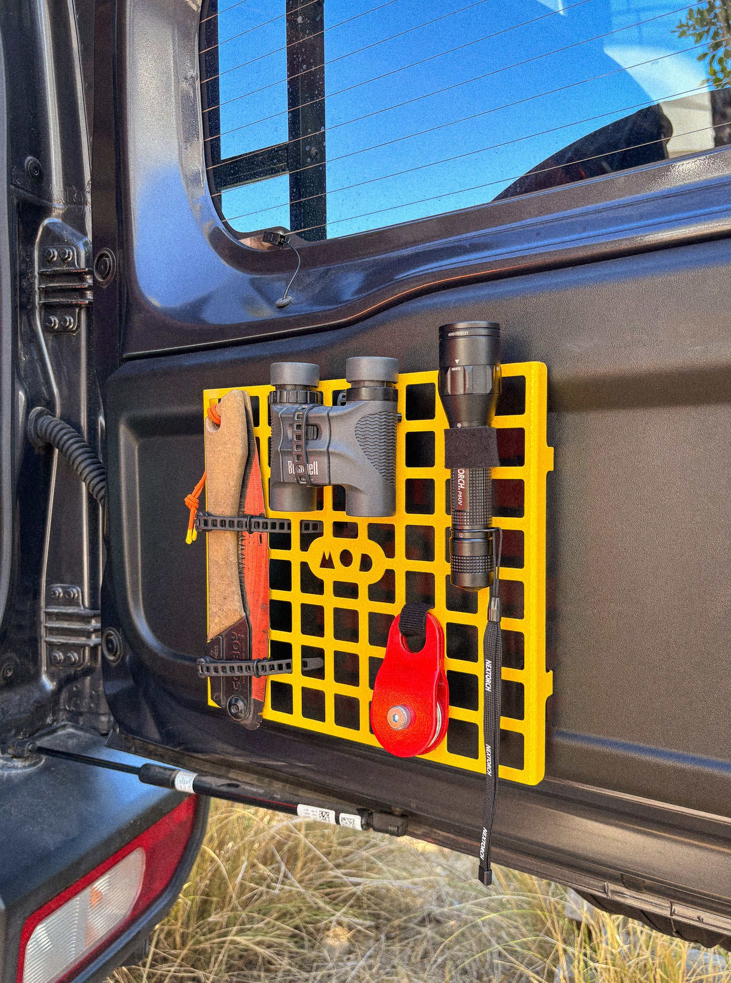 MOD Molly molle panel installed in Jimny 4 XL 5-door on rear door with binoculars, torch and saw mounted