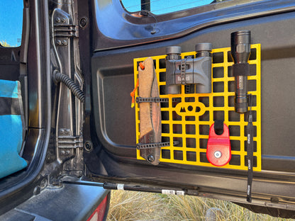 MOD Molly Molle panel installed in Jimny 4 in yellow showing binoculars, torch, saw mounted on molle panel