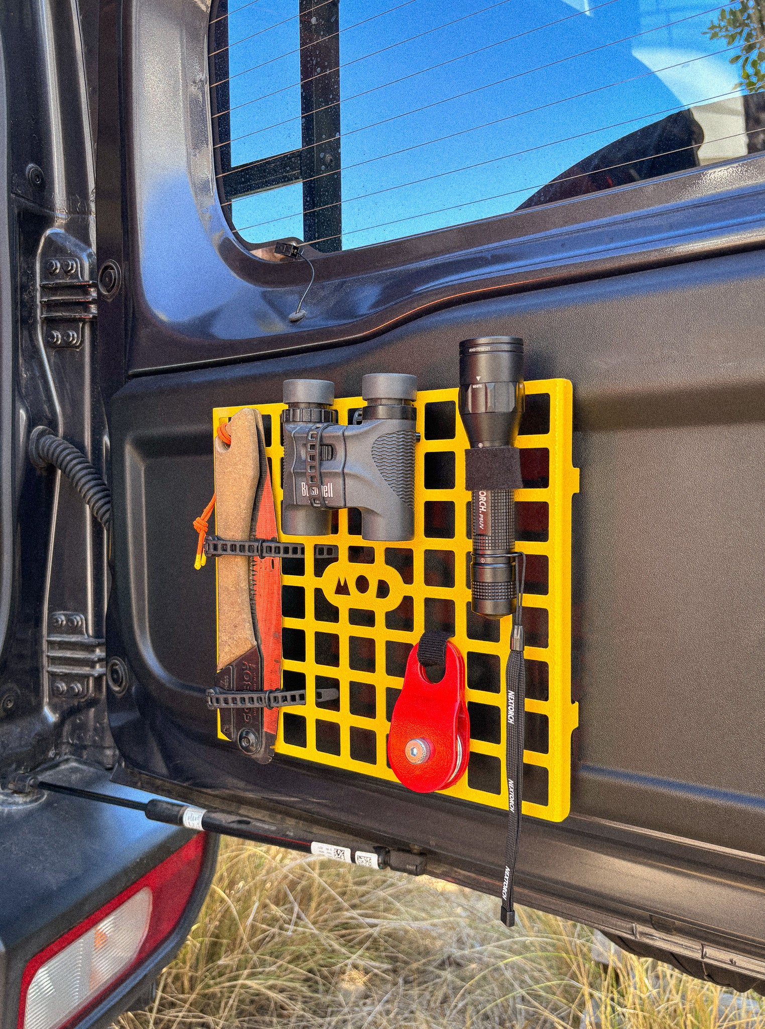 MOD Molly molle panel installed in Jimny 4 XL 5-door on rear door with binoculars, torch and saw mounted