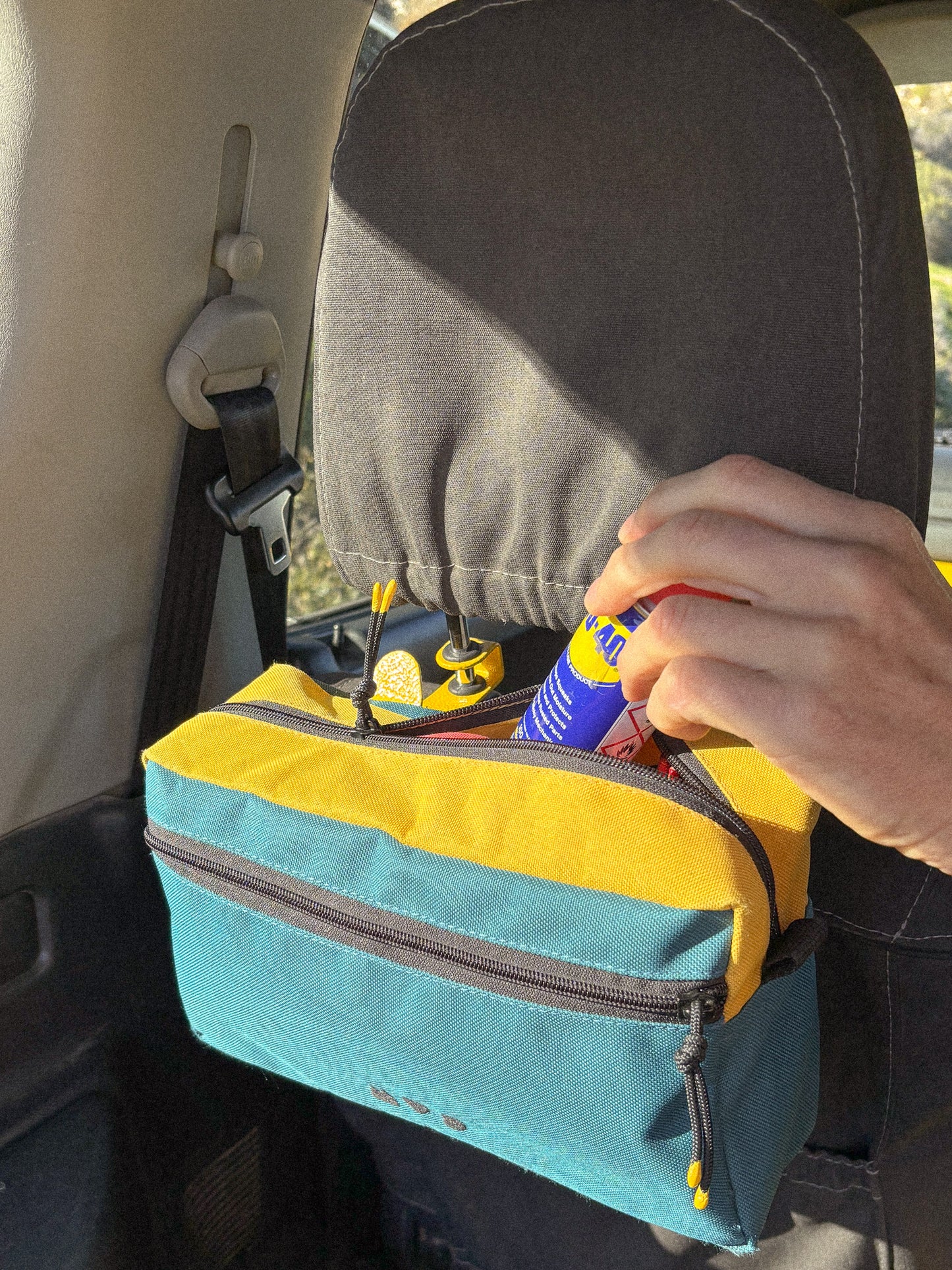Seat Hooks on headrest posts in Suzuki Jimny showing extra storage solution