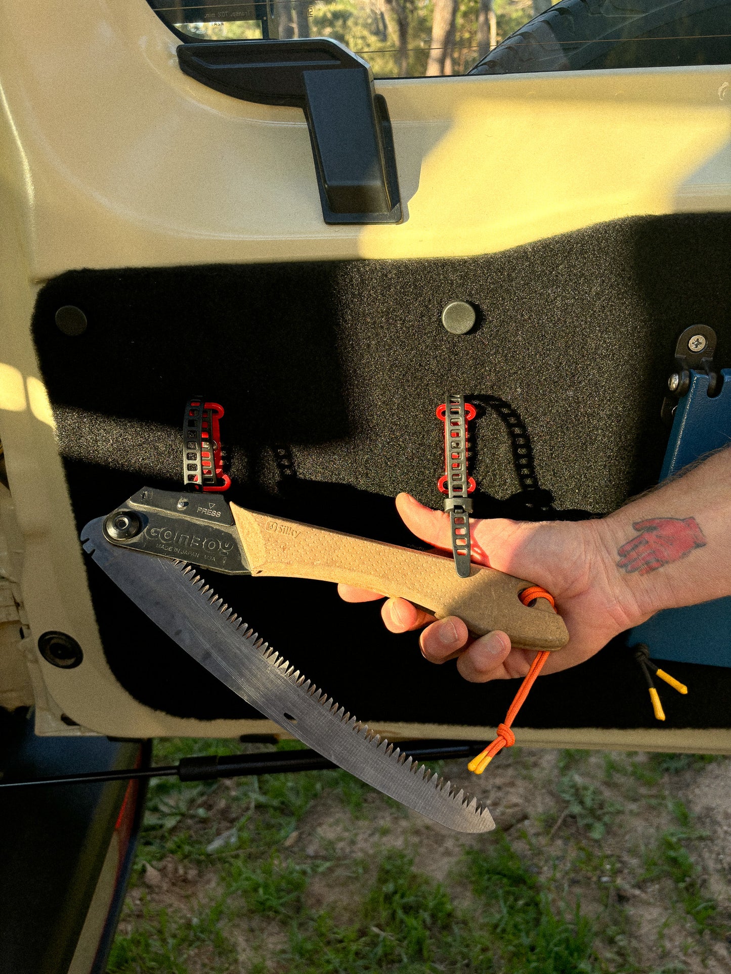 StrapOnz micro-cage cargo carrier in Red on Jimny 4 Rear Door Table Utility Panel with a saw