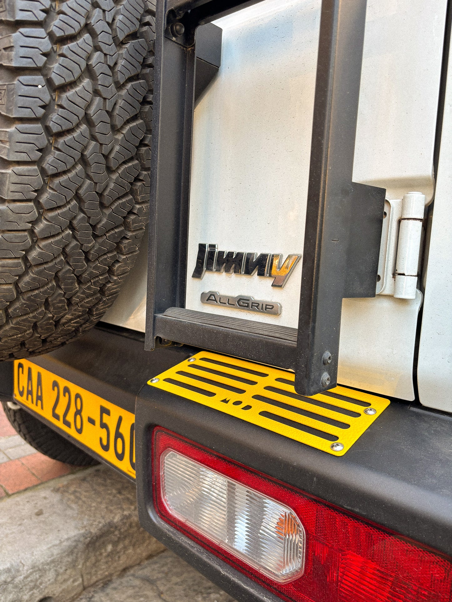 MOD Tread Plates for Jimny 4 mounted on the bumper underneath a rear door ladder